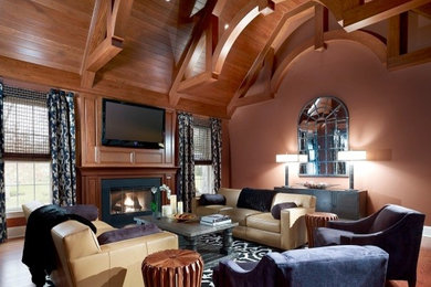 Imagen de sala de estar ecléctica grande con suelo de madera en tonos medios, todas las chimeneas, marco de chimenea de piedra, televisor colgado en la pared y paredes rosas