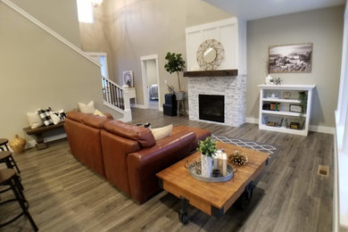 Family room - laminate floor and brown floor family room idea in Seattle with a standard fireplace and a tile fireplace