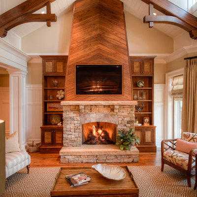 Elegant family room photo in Charleston with a standard fireplace, a stone fireplace and a wall-mounted tv