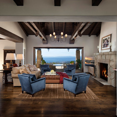 Example of a tuscan dark wood floor family room design in Santa Barbara with white walls, a standard fireplace and a stone fireplace