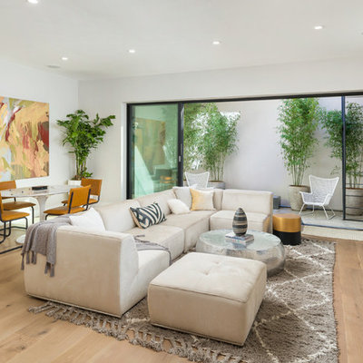 Inspiration for a mid-sized contemporary enclosed light wood floor and beige floor family room remodel in San Francisco with white walls, a wall-mounted tv and no fireplace