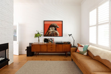 Diseño de sala de estar abierta clásica renovada grande con paredes blancas, suelo de madera en tonos medios, chimenea de doble cara, marco de chimenea de ladrillo, televisor colgado en la pared, suelo marrón y madera