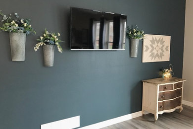 Mittelgroßes, Offenes Klassisches Wohnzimmer ohne Kamin mit blauer Wandfarbe, hellem Holzboden, TV-Wand und grauem Boden in Omaha