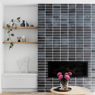 Design ideas for a contemporary open concept family room in Melbourne with white walls, medium hardwood floors, a standard fireplace, a brick fireplace surround, a wall-mounted tv and brown floor.