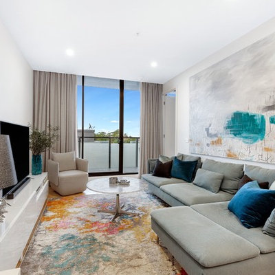 Example of a trendy medium tone wood floor and brown floor family room design in Melbourne with white walls and a tv stand