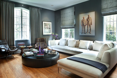 Modelo de sala de estar con biblioteca cerrada moderna extra grande con paredes grises y suelo de madera en tonos medios