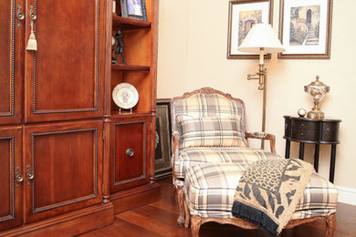 Imagen de sala de estar abierta contemporánea de tamaño medio sin chimenea con suelo marrón, paredes beige, suelo de madera en tonos medios y televisor retractable