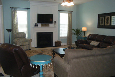 Ejemplo de sala de estar abierta tradicional de tamaño medio con paredes azules, moqueta, todas las chimeneas, marco de chimenea de piedra y televisor colgado en la pared
