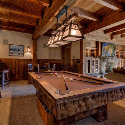 Example of a huge mountain style enclosed carpeted and beige floor family room design in Sacramento with a standard fireplace, a wall-mounted tv, beige walls and a stone fireplace