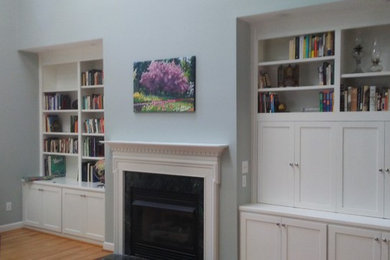 Diseño de sala de estar cerrada minimalista de tamaño medio con marco de chimenea de madera y pared multimedia