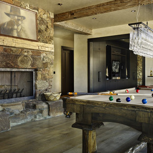 Mountain style game room photo in Denver with beige walls, a standard fireplace and a stone fireplace