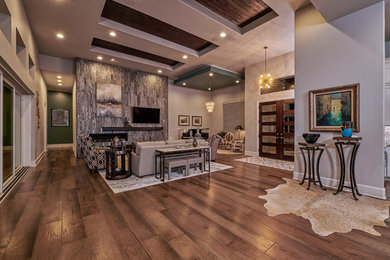Large trendy open concept medium tone wood floor and brown floor family room photo in Austin with gray walls, a ribbon fireplace, a stone fireplace, a wall-mounted tv and a music area