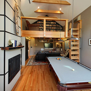 Large urban open concept medium tone wood floor game room photo in Seattle with a wall-mounted tv and multicolored walls