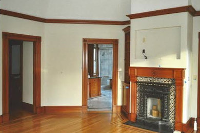Diseño de sala de estar tradicional con paredes beige, suelo de madera clara y todas las chimeneas
