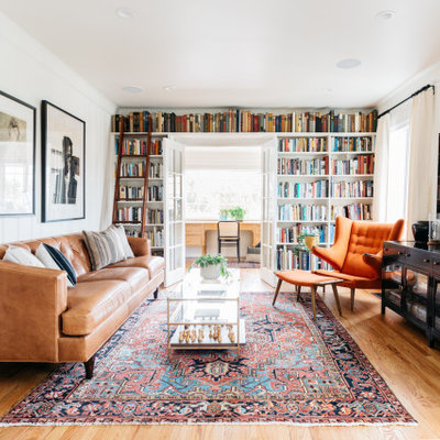 Family room - transitional enclosed medium tone wood floor and brown floor family room idea in Los Angeles with white walls and a wall-mounted tv