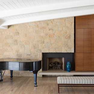 Foto di un soggiorno contemporaneo di medie dimensioni e aperto con sala della musica, pareti bianche, camino classico, pavimento in legno massello medio, cornice del camino in pietra, TV nascosta e pavimento marrone
