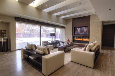 Large trendy open concept porcelain tile and brown floor family room photo in Toronto with beige walls, a ribbon fireplace, a stone fireplace and a media wall