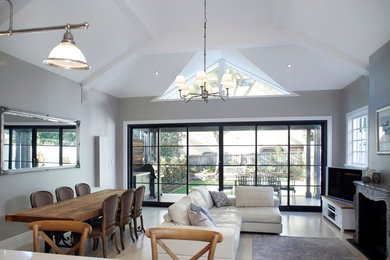 Стильный дизайн: открытая гостиная комната среднего размера в стиле модернизм с серыми стенами, стандартным камином и отдельно стоящим телевизором - последний тренд
