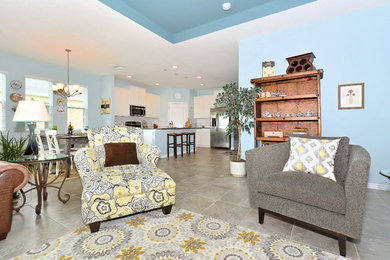 Foto de sala de estar abierta tradicional renovada de tamaño medio sin chimenea con paredes azules, suelo de baldosas de cerámica, televisor independiente y suelo gris