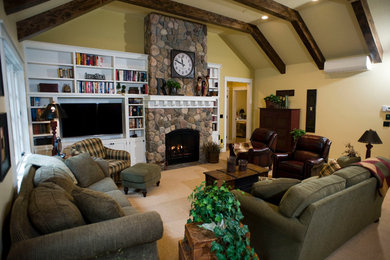 Family room - large rustic enclosed carpeted and brown floor family room idea in Other with beige walls, a standard fireplace, a stone fireplace and a tv stand