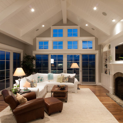 Example of a classic family room design in Denver with a brick fireplace and gray walls