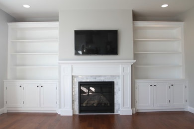 Inspiration for a large classic enclosed games room in Chicago with white walls, light hardwood flooring, a standard fireplace, a stone fireplace surround and a built-in media unit.