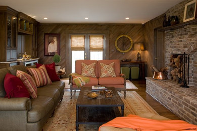 Idées déco pour une salle de séjour classique avec un mur marron, un sol en bois brun, une cheminée standard et un manteau de cheminée en brique.
