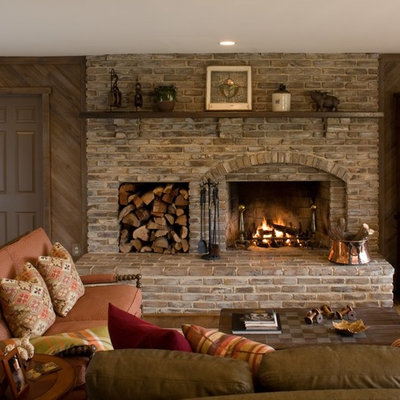 Example of a classic family room design in DC Metro with brown walls, a standard fireplace and a brick fireplace