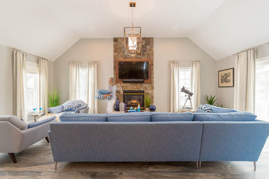 Mid-sized minimalist open concept porcelain tile and blue floor family room photo in Other with gray walls, a standard fireplace, a stone fireplace and a wall-mounted tv