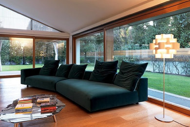 Foto de sala de estar abierta contemporánea de tamaño medio sin chimenea y televisor con paredes blancas y suelo de madera en tonos medios