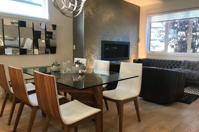 Trendy dining room photo in Calgary with gray walls, a hanging fireplace and a plaster fireplace