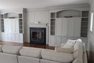 Inspiration for a mid-sized transitional enclosed dark wood floor and brown floor family room remodel in Boston with gray walls, a standard fireplace and a stone fireplace