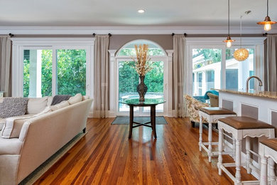 Example of a large trendy open concept medium tone wood floor family room design in Philadelphia with gray walls, no fireplace and a media wall