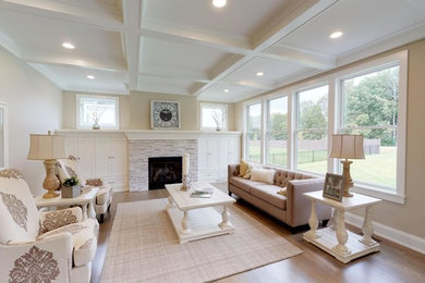 Imagen de sala de estar abierta de estilo de casa de campo grande con paredes grises, suelo de madera clara, todas las chimeneas, marco de chimenea de piedra y suelo gris