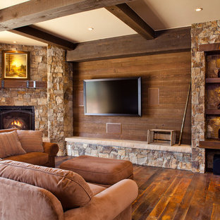 Family room - mid-sized rustic open concept dark wood floor and brown floor family room idea in Denver with a corner fireplace, a stone fireplace, brown walls and a wall-mounted tv