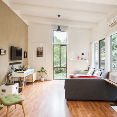 Example of a trendy medium tone wood floor family room design in Melbourne with white walls and a wall-mounted tv