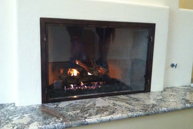 フェニックスにある中くらいなトラディショナルスタイルのおしゃれな独立型ファミリールーム (白い壁、標準型暖炉、漆喰の暖炉まわり、テレビなし) の写真