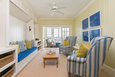 Example of a beach style enclosed carpeted family room design in Charleston with yellow walls