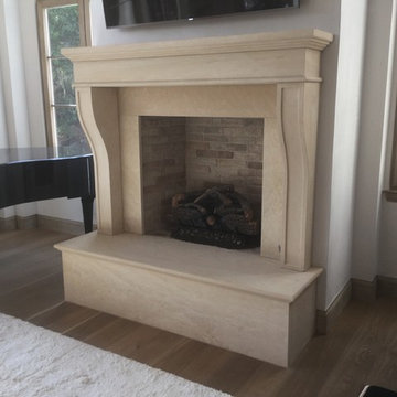 Italian Style hand-carved stone fireplace with a raised hearth.