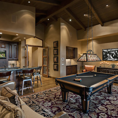 Example of a mountain style enclosed medium tone wood floor and brown floor family room design in Phoenix with beige walls and a wall-mounted tv