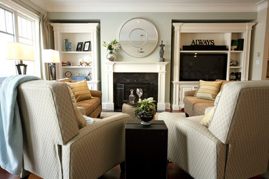 Example of a mid-sized classic open concept family room design in Toronto with a standard fireplace, a wood fireplace surround, a media wall and gray walls
