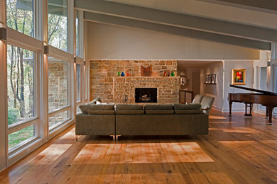Inspiration for a large timeless open concept medium tone wood floor and brown floor family room remodel in Baltimore with gray walls, a standard fireplace, a stone fireplace, no tv and a music area