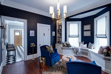 Imagen de sala de estar cerrada tradicional de tamaño medio sin chimenea con paredes negras, suelo de madera en tonos medios y suelo marrón