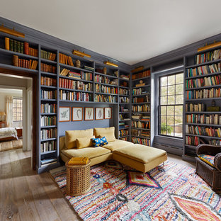 Eklektische Bibliothek mit lila Wandfarbe, braunem Holzboden und braunem Boden in New York