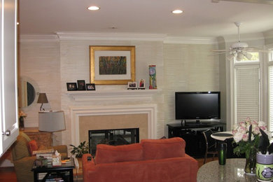Foto de sala de estar cerrada clásica renovada de tamaño medio con paredes multicolor, suelo de madera en tonos medios, chimenea de doble cara, marco de chimenea de piedra y televisor independiente