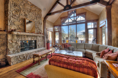 Inspiration for a large rustic open concept family room remodel in Denver with a standard fireplace and a stone fireplace