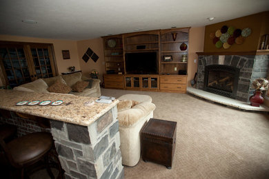 Diseño de sala de estar abierta clásica de tamaño medio con paredes marrones, moqueta, chimenea de esquina, marco de chimenea de piedra, televisor independiente y suelo beige