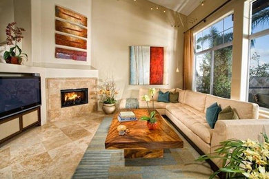 サンディエゴにある高級な中くらいな地中海スタイルのおしゃれなオープンリビング (ベージュの壁、トラバーチンの床、横長型暖炉、タイルの暖炉まわり、壁掛け型テレビ、ベージュの床) の写真