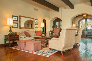 Inspiration for a large southwestern open concept medium tone wood floor and brown floor family room remodel in Phoenix with beige walls