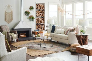 Inspiration for a medium sized bohemian enclosed living room in Charlotte with white walls, dark hardwood flooring, a wood burning stove, a plastered fireplace surround, no tv and brown floors.